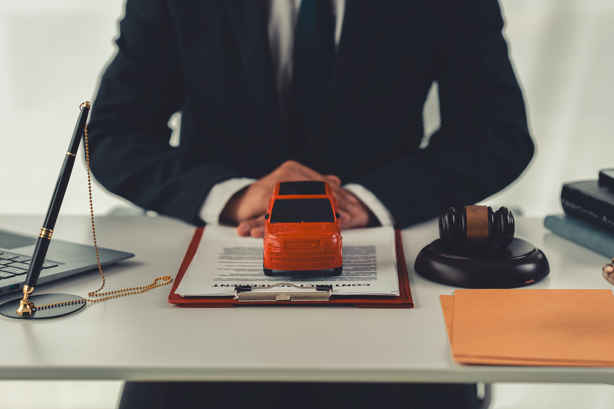 A toy car with a person holding a judge's hammer, simplicity Buying and selling cars Machine seizure trial ownership recognition Close-up pictures